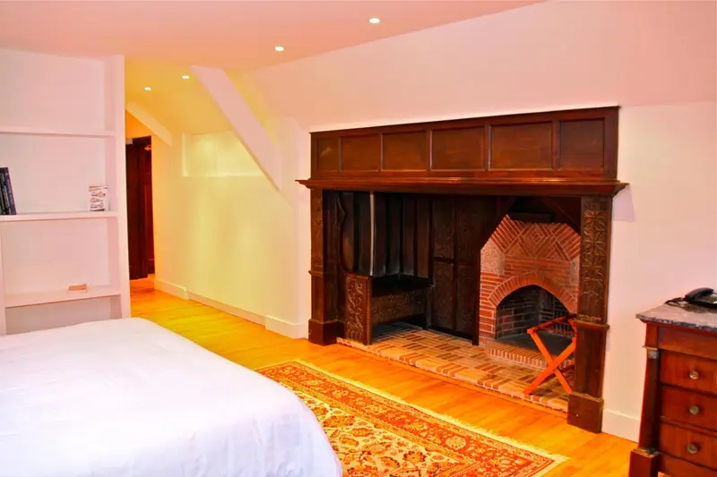 Une chambre lumineuse avec un grand foyer en bois et une décoration chaleureuse.