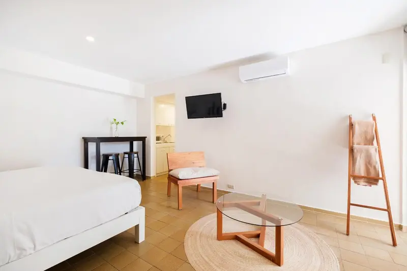 Espace de vie lumineux avec un lit, une table et des chaises.