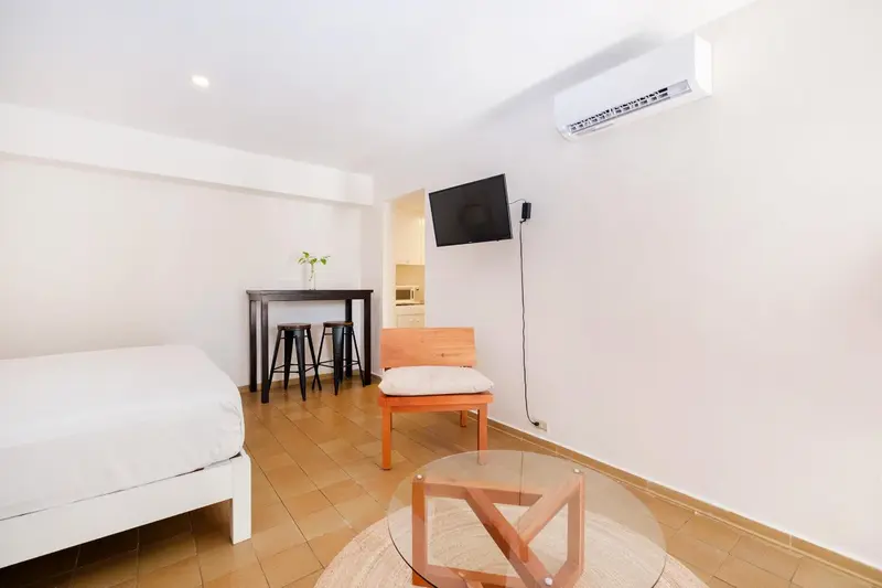 Une chambre lumineuse avec un coin repas et un espace détente.