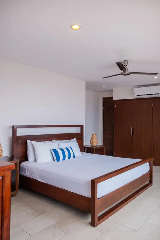 Une chambre lumineuse avec un grand lit et un mobilier en bois.