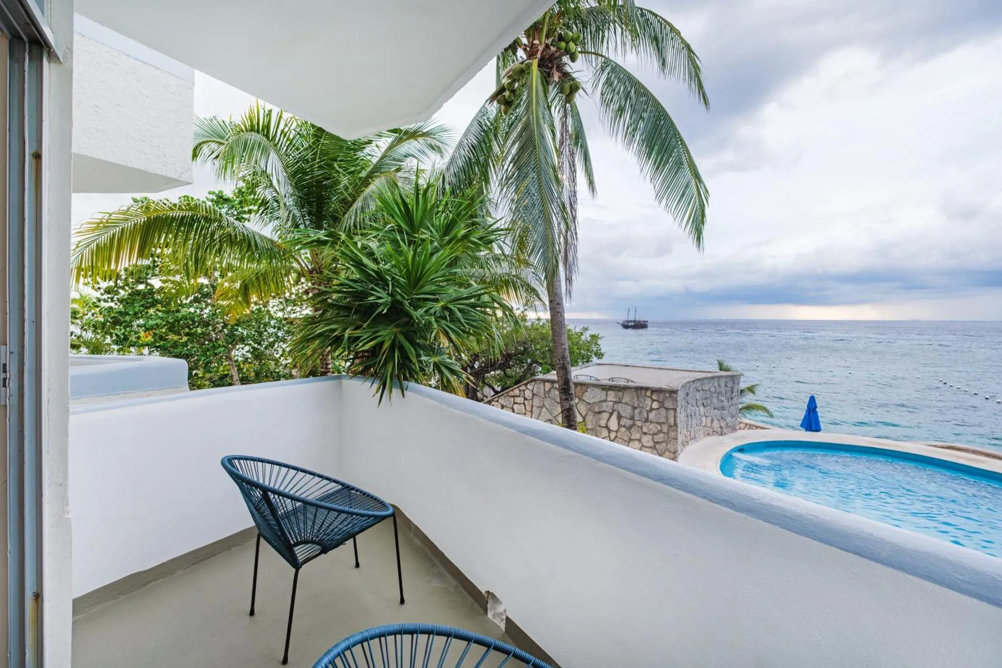 Une terrasse avec mobilier d'extérieur offre une vue sur la mer et une piscine.