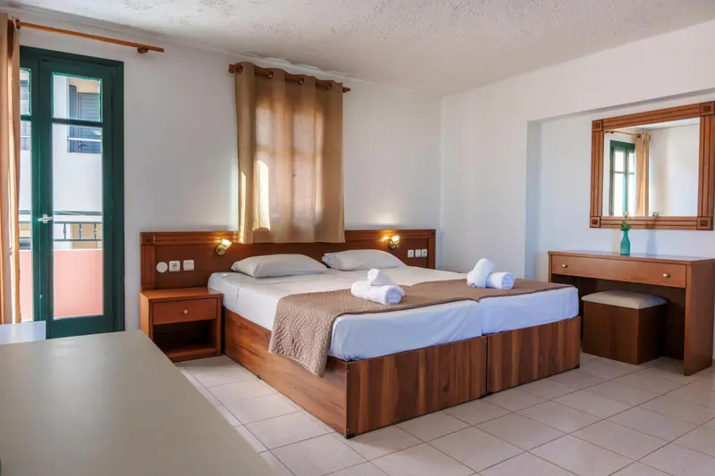 Une chambre lumineuse avec un grand lit et un mobilier en bois.