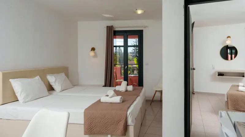 Une chambre lumineuse avec un lit double et un accès à une terrasse.
