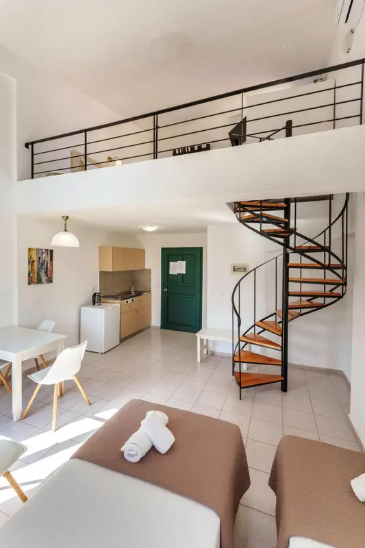 Une cuisine ouverte sur un espace de vie avec un escalier en colimaçon.