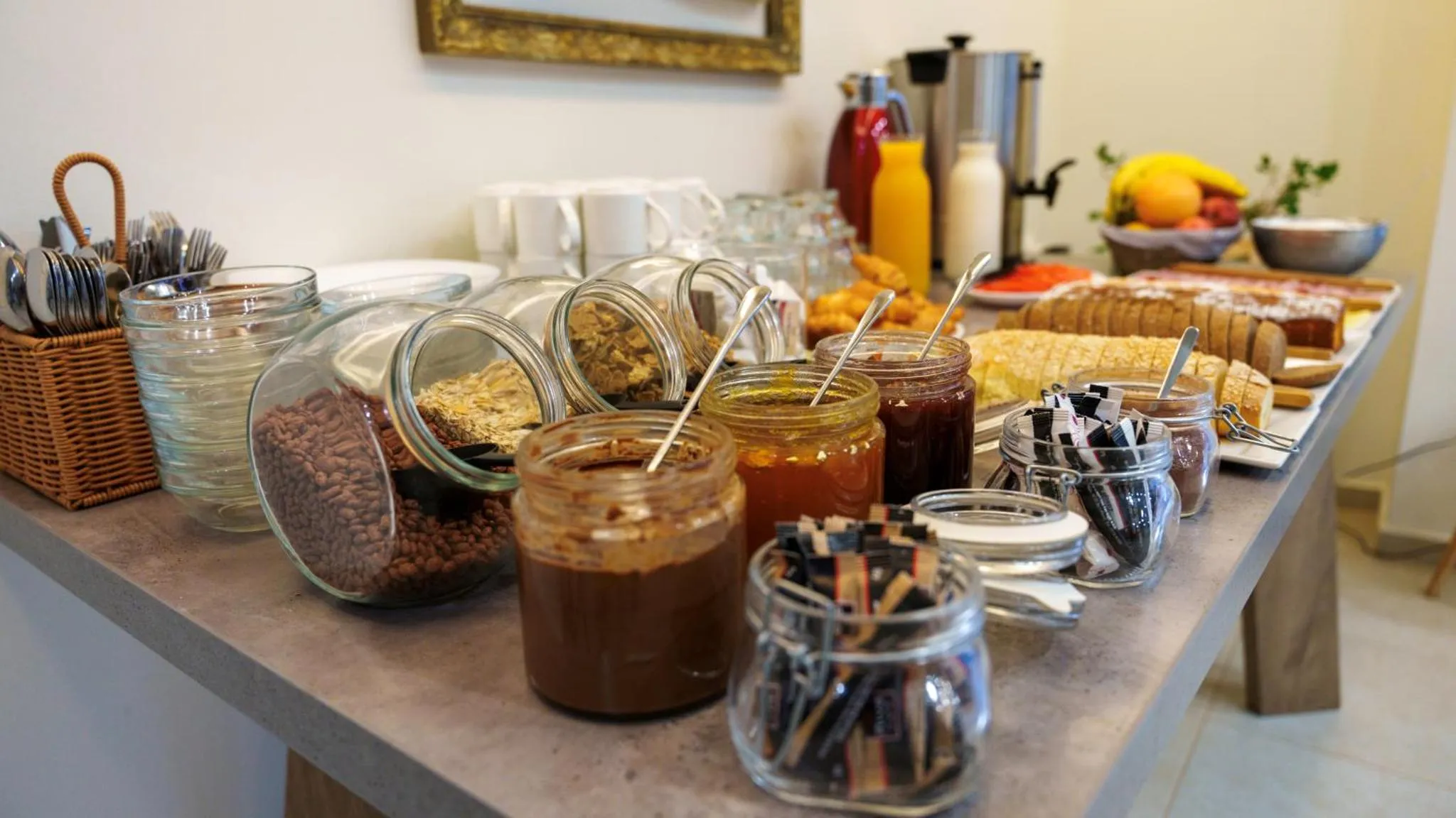 Un buffet propose des céréales, des confitures, des viennoiseries et des fruits frais.