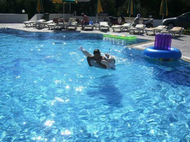 Une personne se détend sur un flotteur dans une piscine ensoleillée.