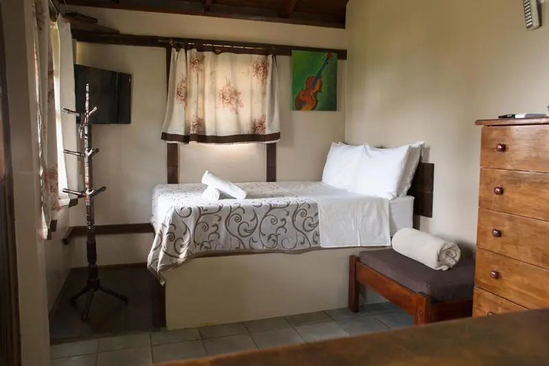 Une chambre lumineuse avec un lit simple et une commode en bois.