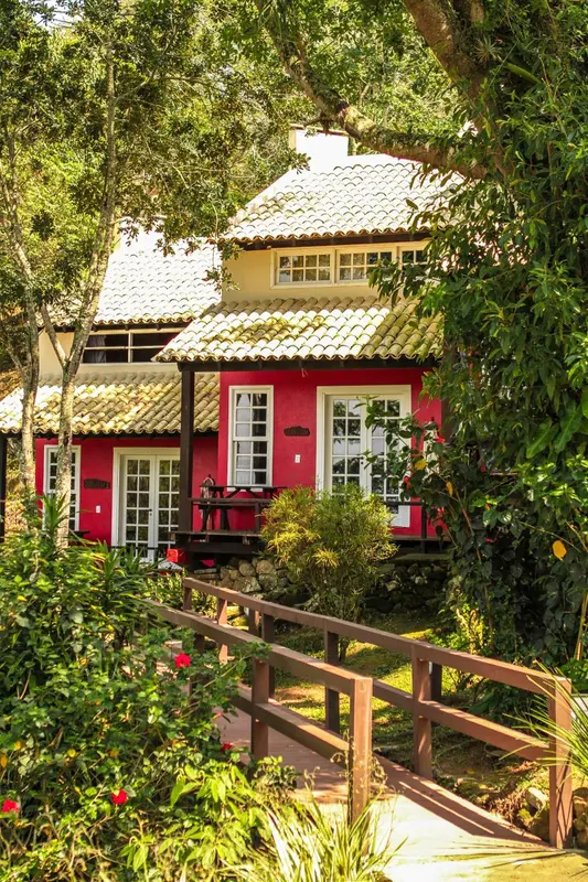 Bâtiment à toit de tuiles rouges entouré d'une végétation luxuriante.