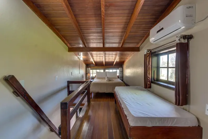 Une chambre mansardée avec un lit double et un lit simple.