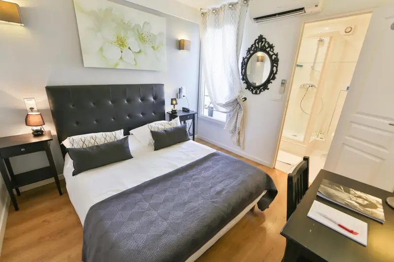 Une chambre avec un grand lit et une salle de bain attenante.