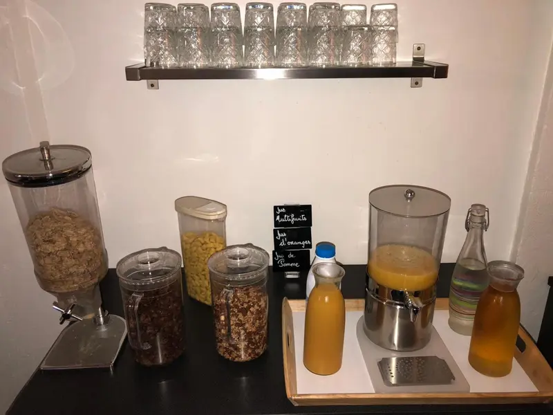 Un buffet propose des céréales, des fruits secs et des jus de fruits.