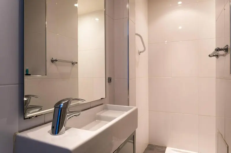 Une salle de bain moderne avec lavabo et miroir.