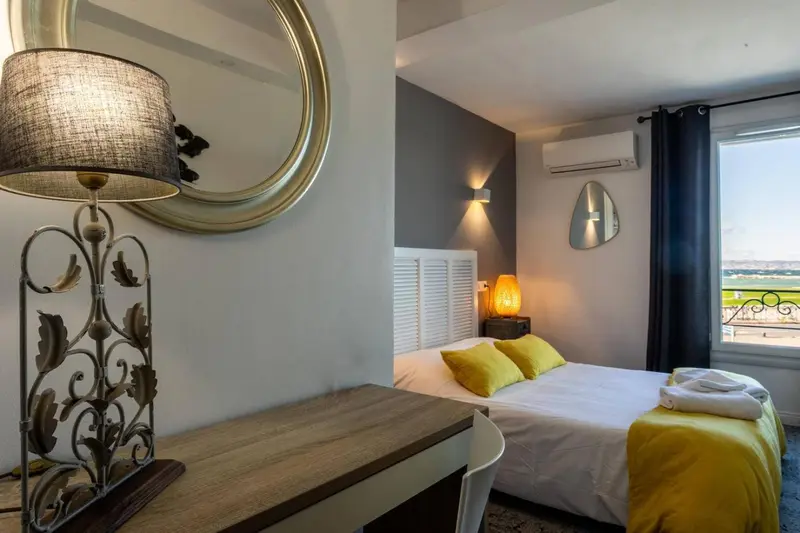 Une chambre lumineuse avec un lit jaune et un bureau en bois.
