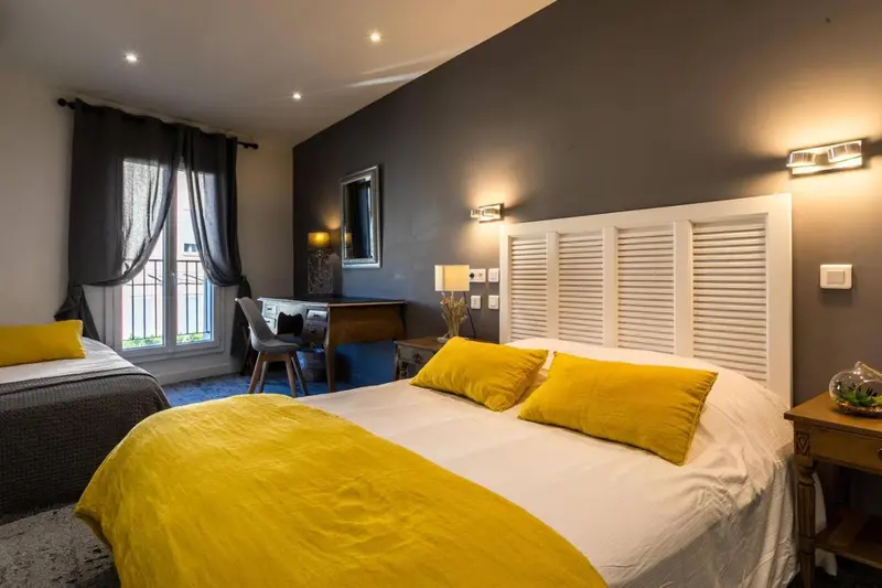 Une chambre lumineuse avec un lit double et un lit simple.