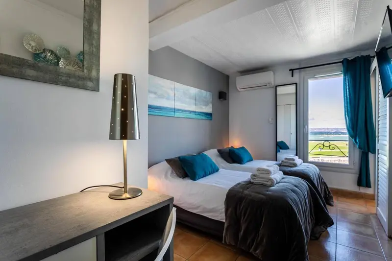 Une chambre lumineuse avec un lit double et un bureau.