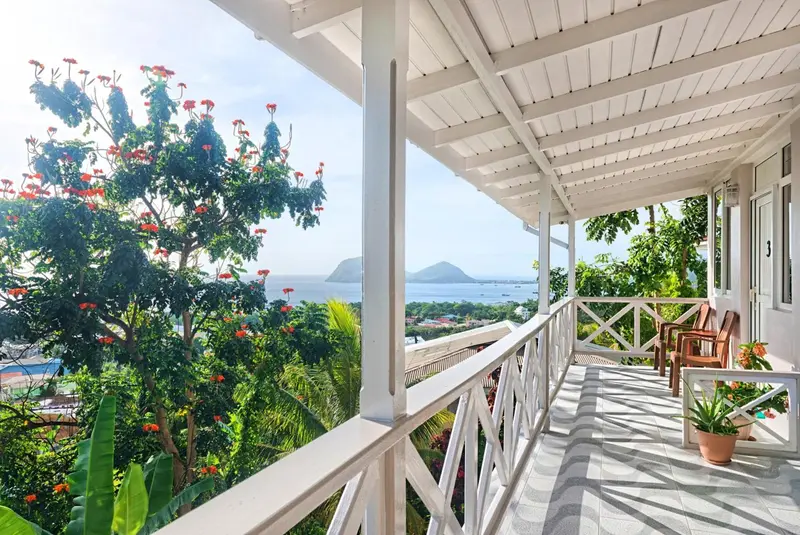 Terrasse avec vue sur la mer et la végétation luxuriante.