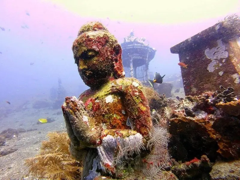 Statue de Bouddha colonisée par la vie marine au fond de l'océan.