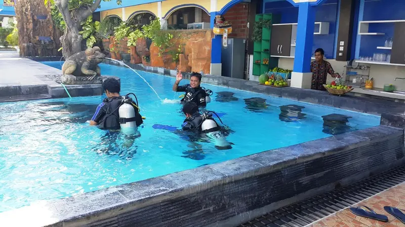 Deux personnes en équipement de plongée sortent d'une piscine.
