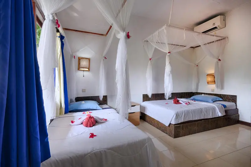 Deux lits simples décorés de fleurs dans une chambre lumineuse.