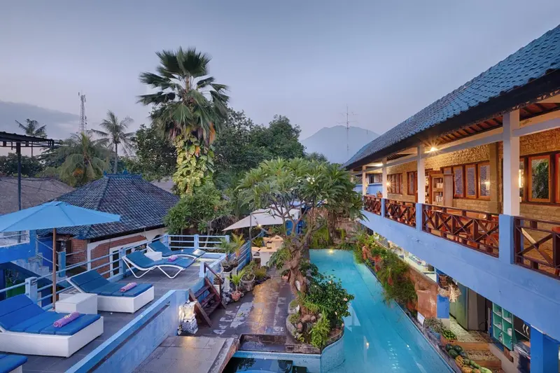 Vue d'un espace extérieur avec piscine et végétation tropicale.