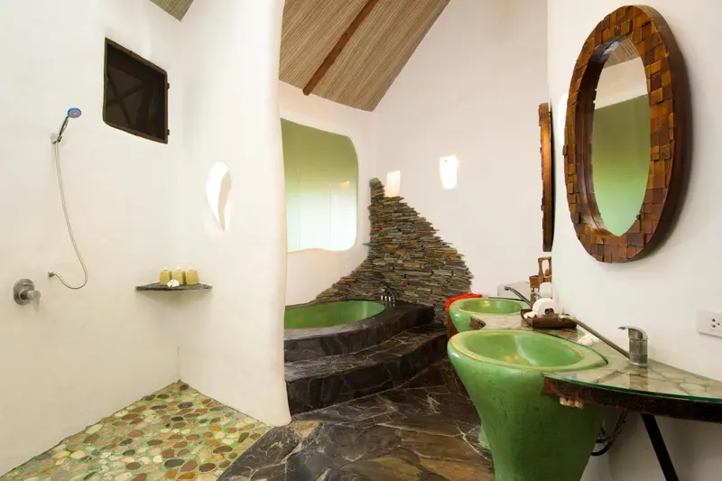 Salle de bain ouverte avec douche à l'italienne et baignoire.