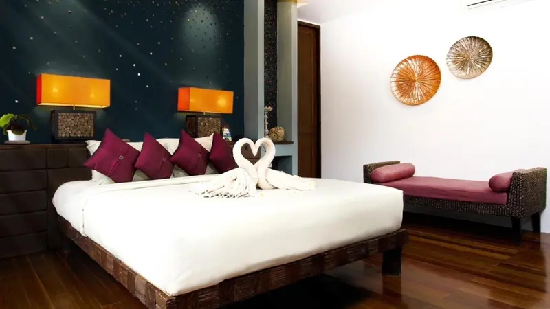 Une chambre avec un lit décoré de serviettes en forme de cygnes.