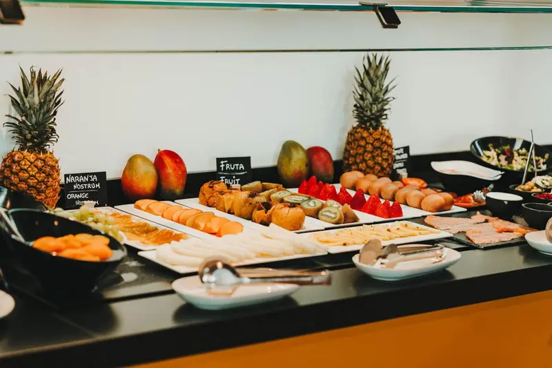 Un buffet propose une variété de fruits frais et de pâtisseries.