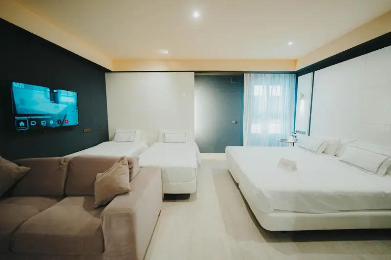 Une chambre moderne avec canapé, lits et télévision.