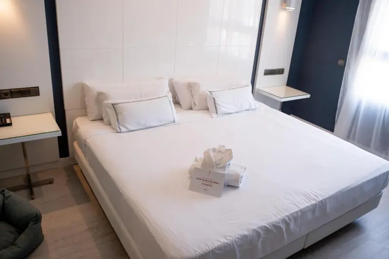 Un lit double blanc est fait dans une chambre lumineuse.