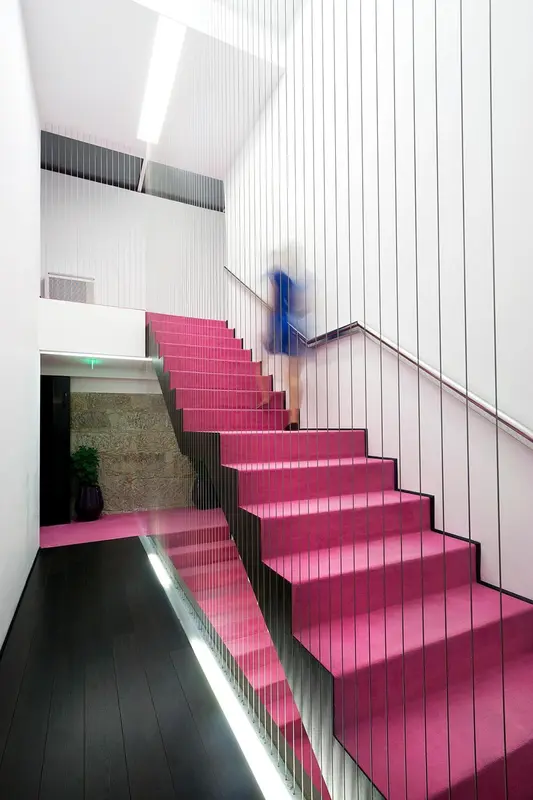 Escalier rose vif dans un intérieur moderne et minimaliste.