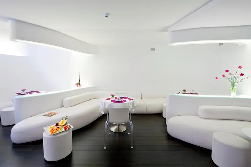 Espace de détente moderne avec canapés blancs et table basse.