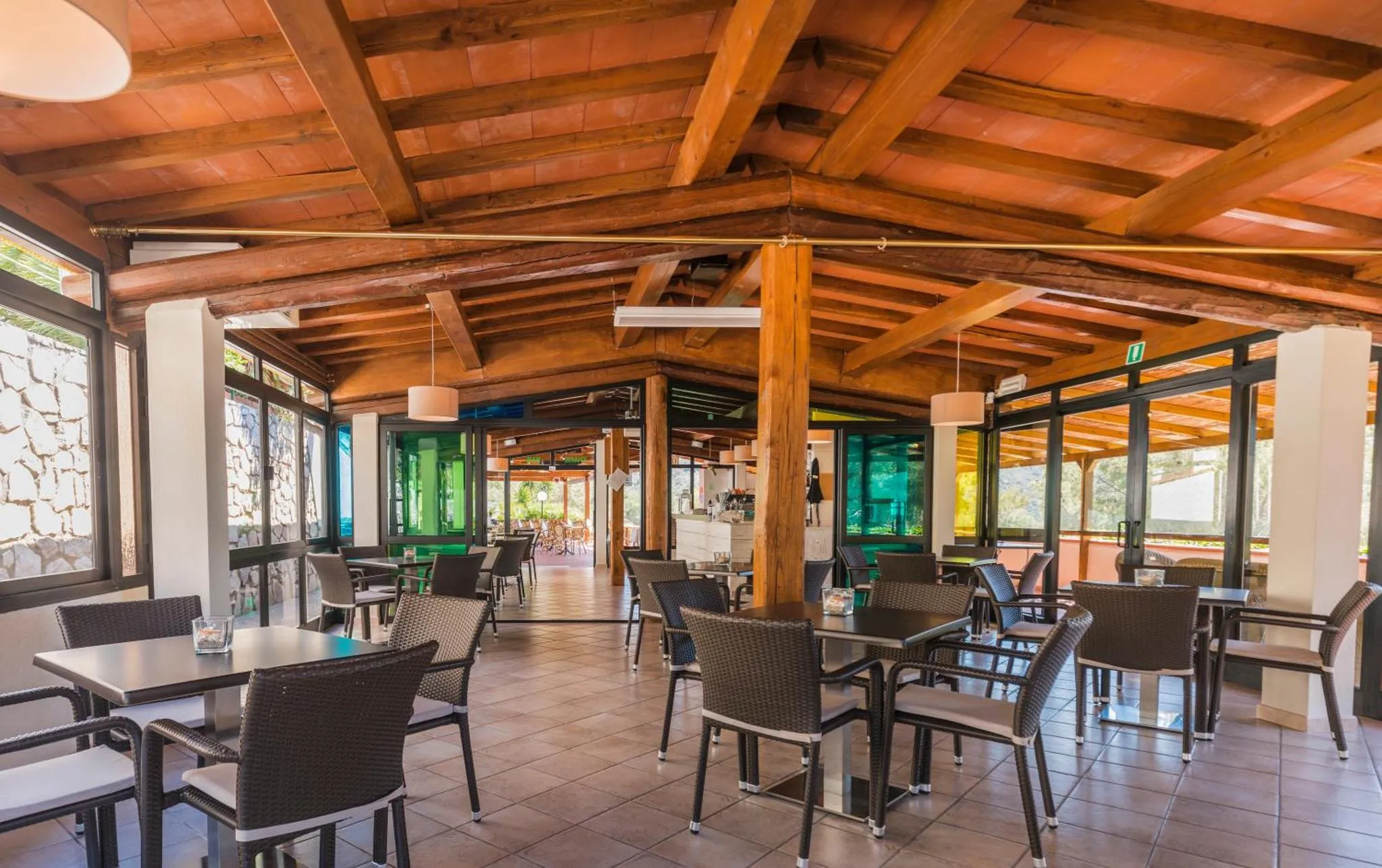 Une salle lumineuse avec des tables et des chaises en osier.