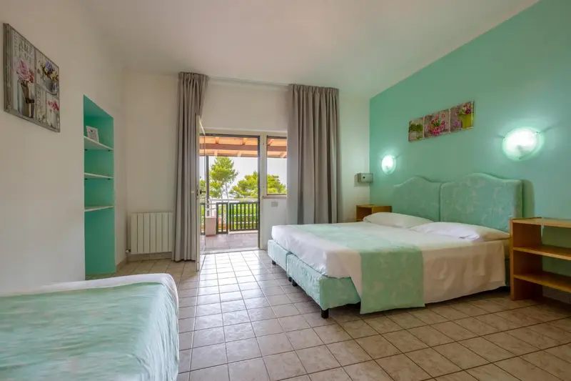 Une chambre lumineuse avec un lit double et un accès à une terrasse.