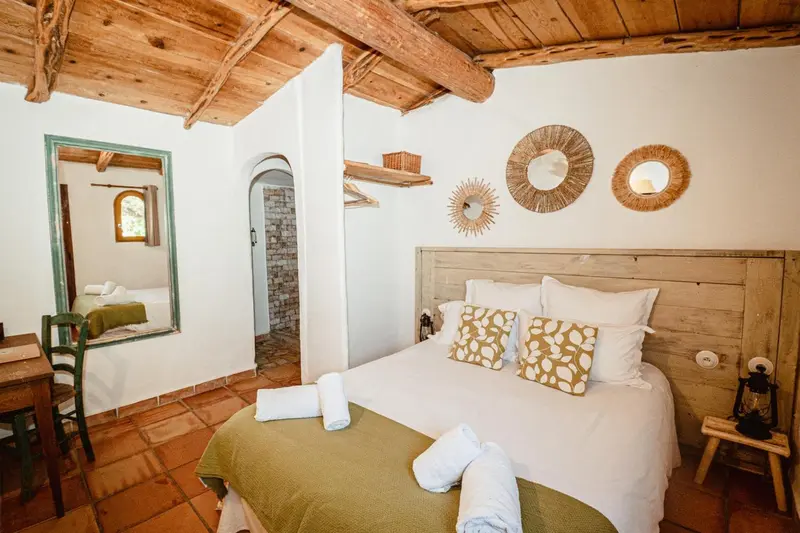 Une chambre lumineuse avec un grand lit et une décoration murale en forme de soleil.