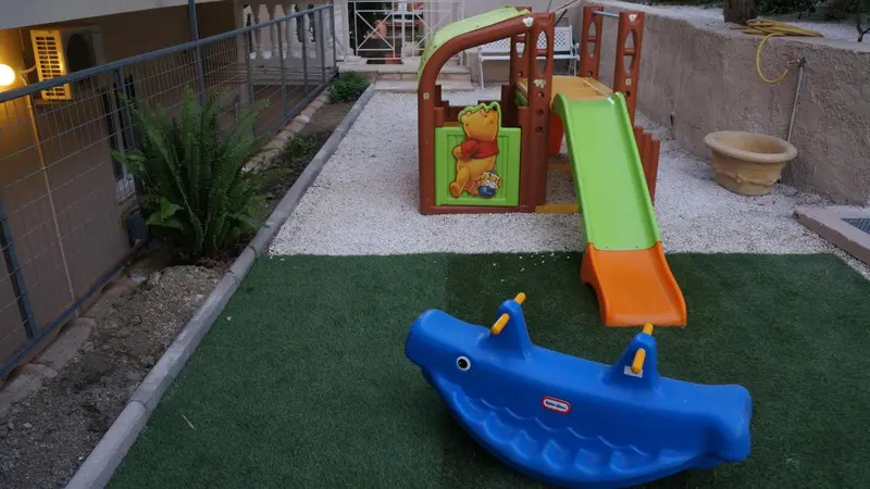 Un espace de jeux pour enfants avec un toboggan et un jeu à bascule.