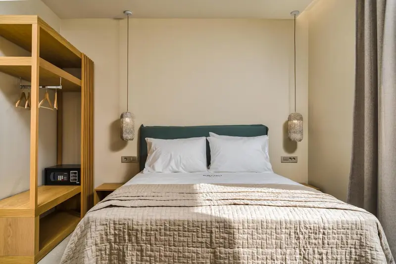 Une chambre lumineuse avec un grand lit et un espace de rangement.