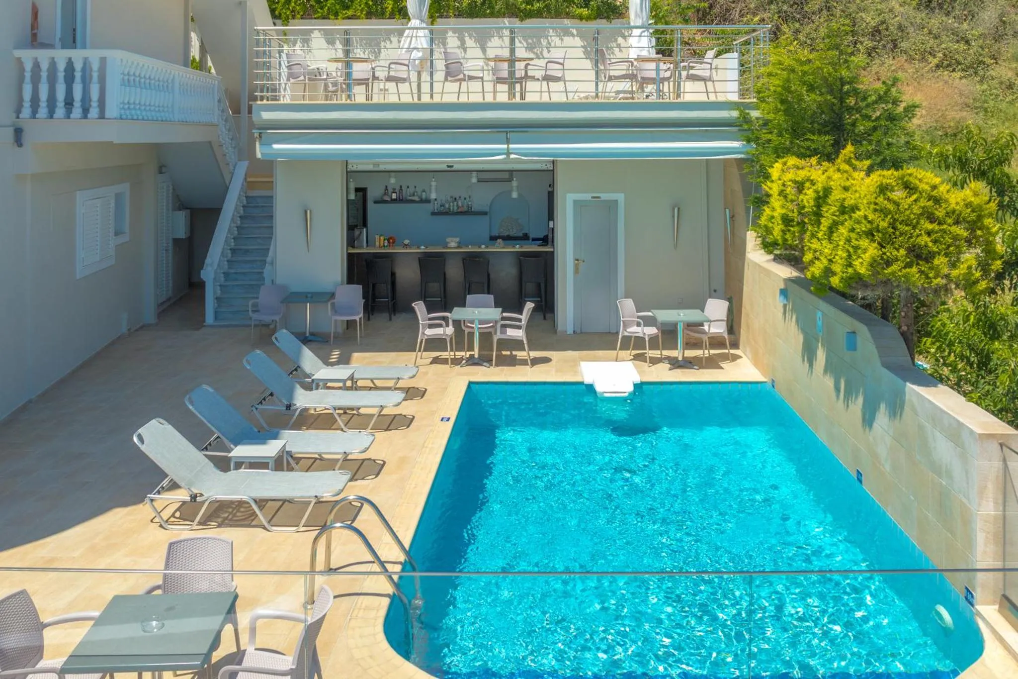 Terrasse avec piscine et bar en bord de mer.