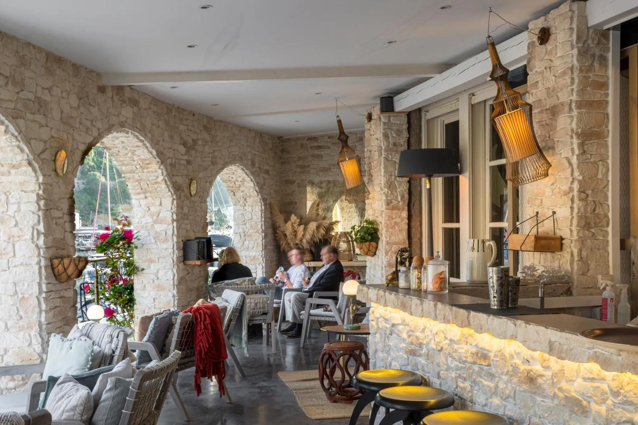 Espace de détente extérieur avec des fauteuils et un comptoir éclairé.