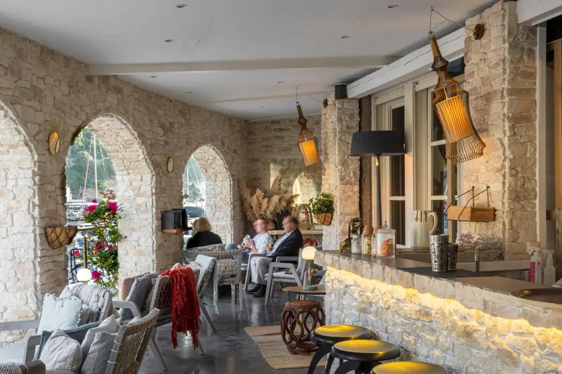 Espace de détente extérieur avec des fauteuils et un comptoir éclairé.