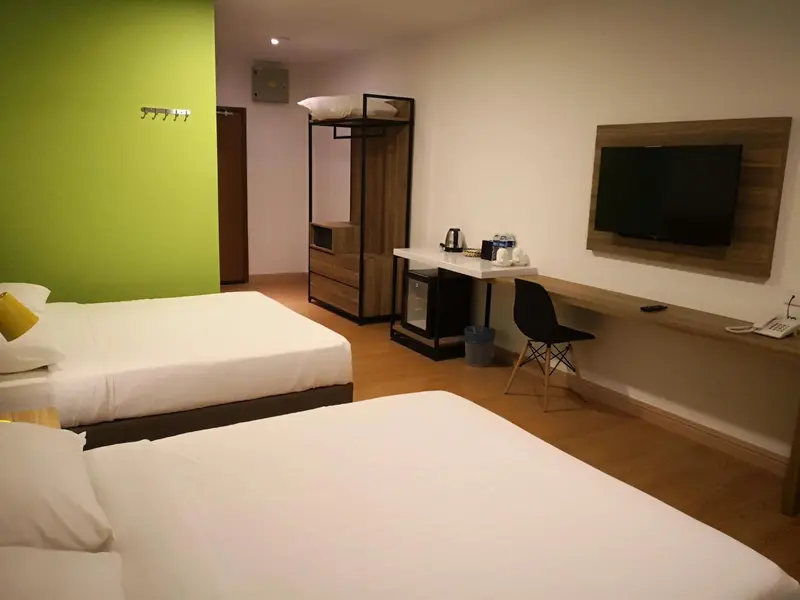 Chambre avec deux lits et un espace bureau.