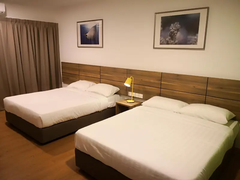 Une chambre avec deux lits simples et une décoration sobre.