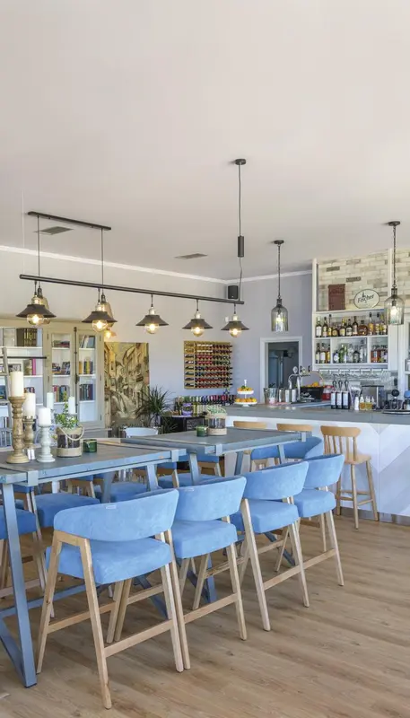 Une salle lumineuse avec un long comptoir et des tables à manger.