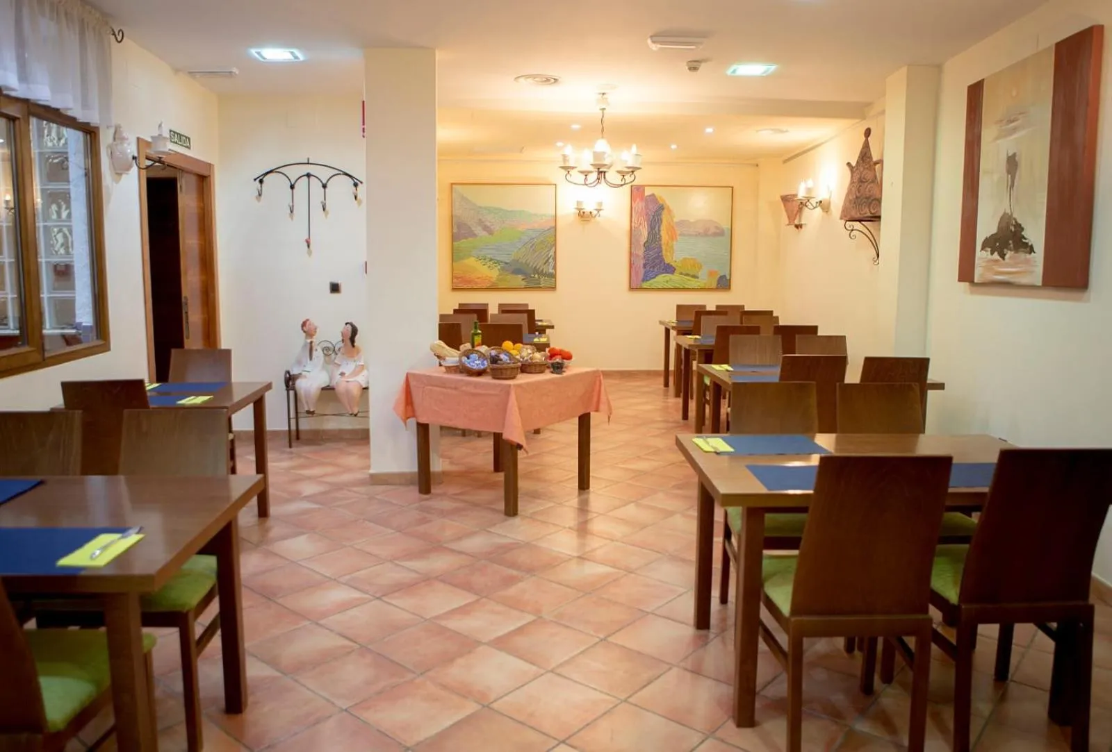 Une salle lumineuse avec des tables dressées pour le repas.