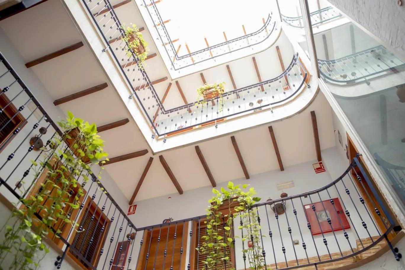 Vue d'une cour intérieure avec des balcons fleuris et des escaliers.