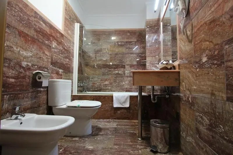 Une salle de bain avec douche, baignoire et toilettes.