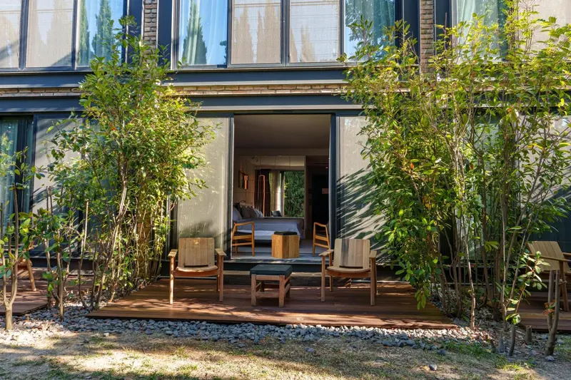 Terrasse aménagée avec salon et vue sur une chambre.