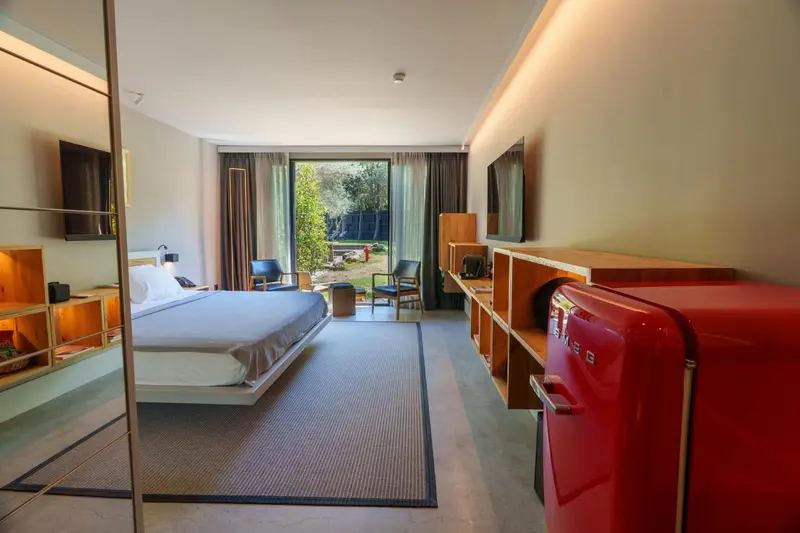 Une chambre lumineuse avec un lit double et un accès à une terrasse.
