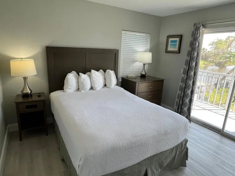 Une chambre lumineuse avec un grand lit et une vue sur l'extérieur.