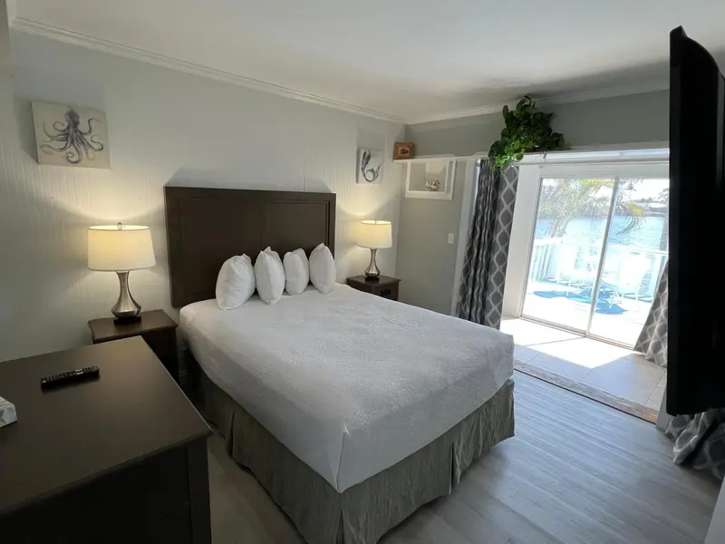 Une chambre lumineuse avec un grand lit et une vue sur l'extérieur.