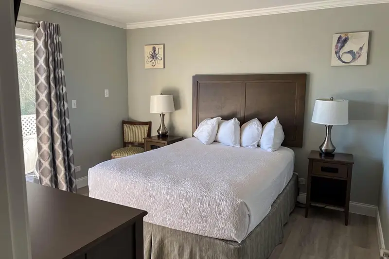 Une chambre lumineuse avec un grand lit et des tables de chevet.